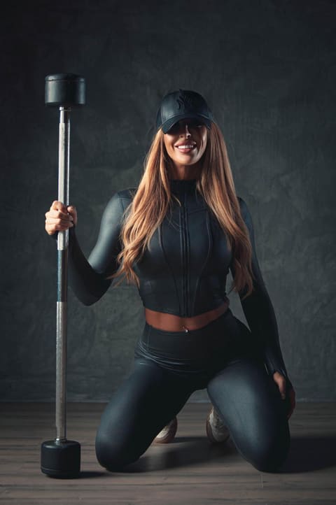 Noelia arrodillada junto a una barra con pesas